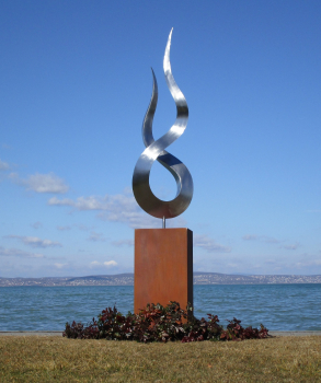 Stainless steel flame artwork on rusty column